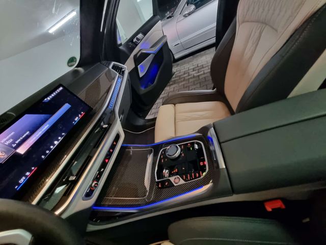 Detailreinigung der Mittelkonsole eines BMW X7 mit Carbon-Zierleisten und Ambientebeleuchtung